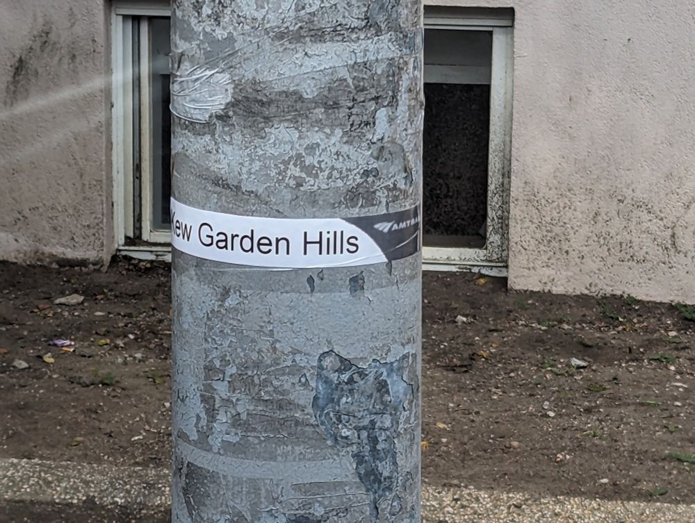 Paper taped to a light pole with Amtrak logo and "Kew Gardens Hills"