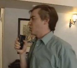 Alan Partridge speaking into a dictaphone