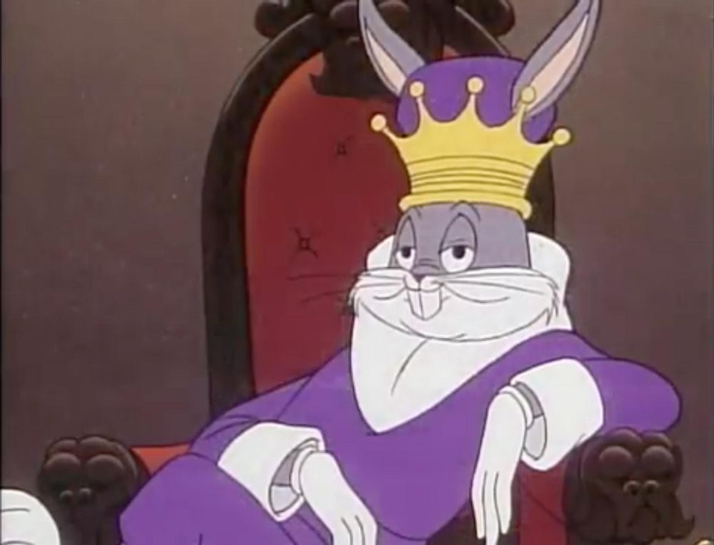 Bugs Bunny sassily leaning on the arm rest of a throne while wearing a crown