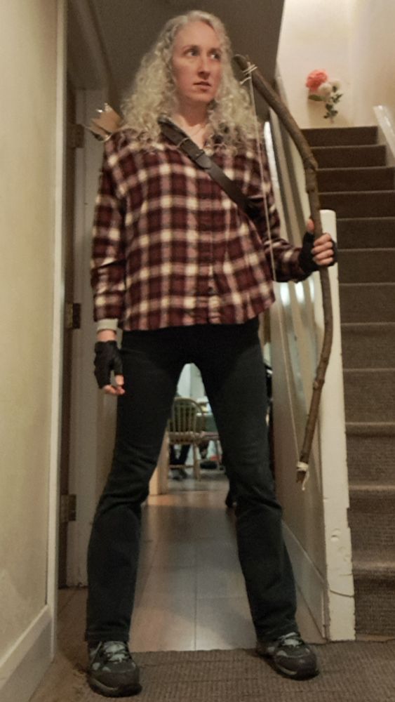 I'm dressed as Carol from the walking dead. Red check shirt with fingerless gloves, bow and arrow.