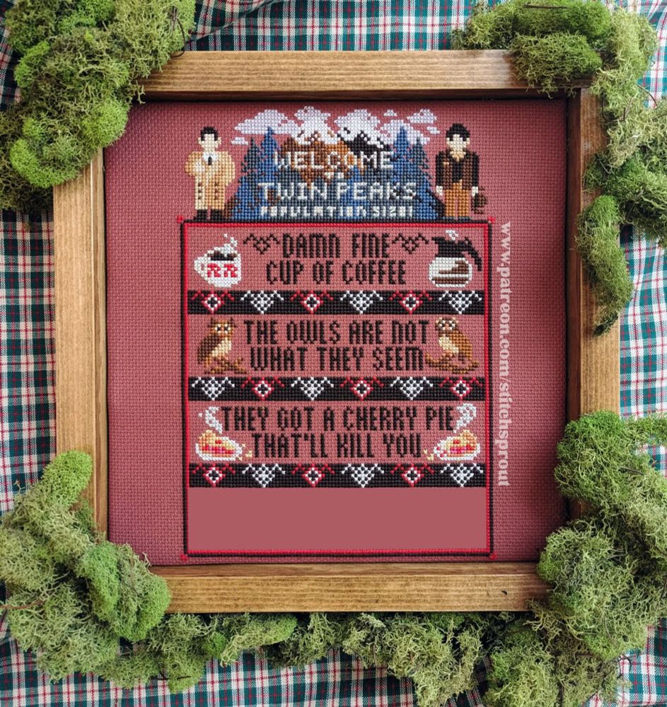 A photo of a framed cross stitch piece showing a sampler in the theme of the cult TV show, Twin Peaks