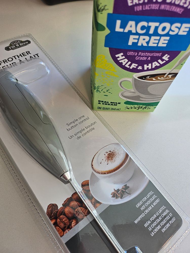 brand new handheld milk frother and carton of lactose free half and half
