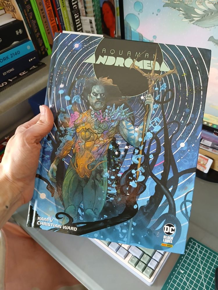 Mão segurando o quadrinho da DC "Aquaman: Andrômeda", do Ram V e do Christian Ward