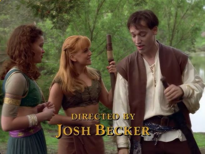 Subsequent framegrab from the aforementioned XENA. From the same setup, Joxer now stands, left hand either sheathing or unsheathing a long sword in a scabbard at his belt, alongside two entirely different women. To his immediate right, an almost impossibly beautiful diminutive copperhaired lesbian in a mottled green midriff top and a long wrapped burlap skirt*. One hand on a long wooden staff, she stares at him grinning. 

To her right, back aligned at the frame's left edge, a longhaired brunette** wearing a shortsleeved olive midriff top beneath a green cropped vest edged by and spangled with gold. Around her waist, a long pleated aquamarine skirt is belted by a silk fuchsia band speckled with golden starbursts. 

Overlaid in treatment and position similar to the titlecard, "Directed By Josh Becker"

Josh Becker passed away a few days ago, and far too soon at age 67. A foundational associate of Sam Raimi's Renaissance Pictures gang, he'd go on to have considerable success in the industry, eventually writing and directing a good whack of television in addition to his entertaining and energetic independent feature films. A guiding light for cinephiles of a certain age and disposition. He'll be missed.

This Xena of his is a bit of a departure, stemming from Lucy Lawless' sidelining due to serious injury. She's barely in it, and so it instead becomes a fun showcase for Becker pal Ted Raimi's adoration of Bob Hope, and a chance for him to also play charming rapscallion in addition to bumbling goofball. Full of dumb energy. Even features a memorable bespoke, Becker-initiated musical theme. Good times.

*(finding it hard to believe there's anyone who wouldn't recognise Renée O'Connor as Gabrielle. Then again, maybe every time she shows up you immediately faint and bonk your noggin. Not uncommon! As I understand it.)

**(This episode's guest lead, "Illeandra," played by the actress Mandy Gillette, who is now retired and practicing Traditional Chinese Medicine in Calgary.)