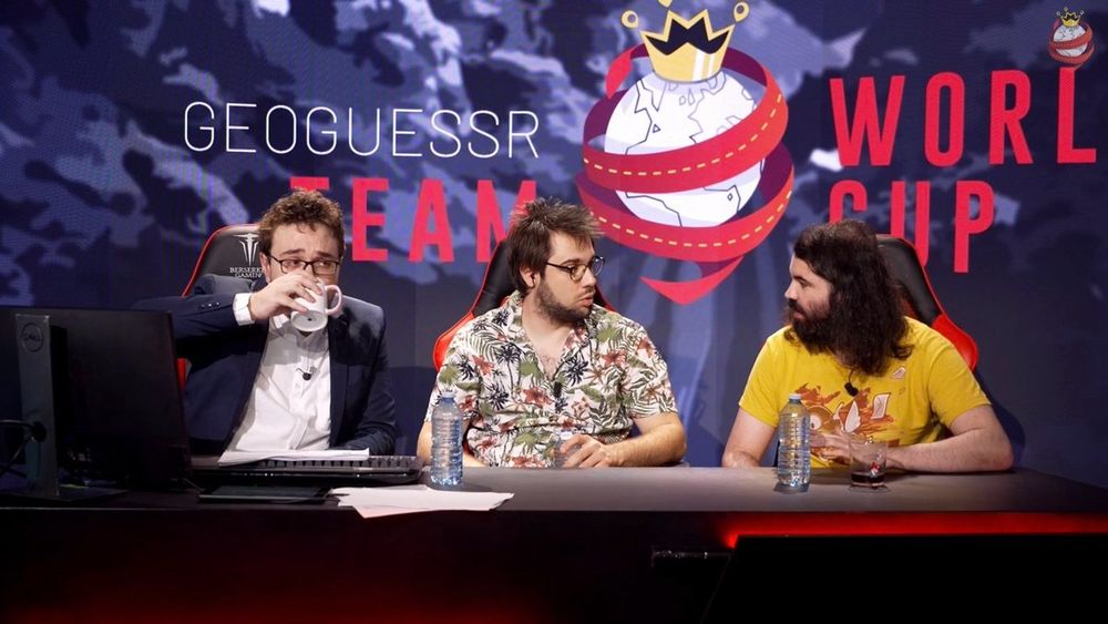 Antoine Daniel, Monté et JDay présentant la coupe du monde Geoguessr 2022. Antoine en costume, Monté en chemise à fleurs et JDay en t-shirt jaune