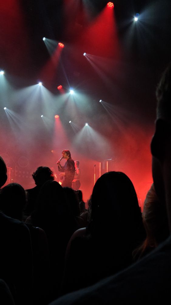 a stage at the Salt Shed lit in red lights with the lead singer of Cage the Elephant