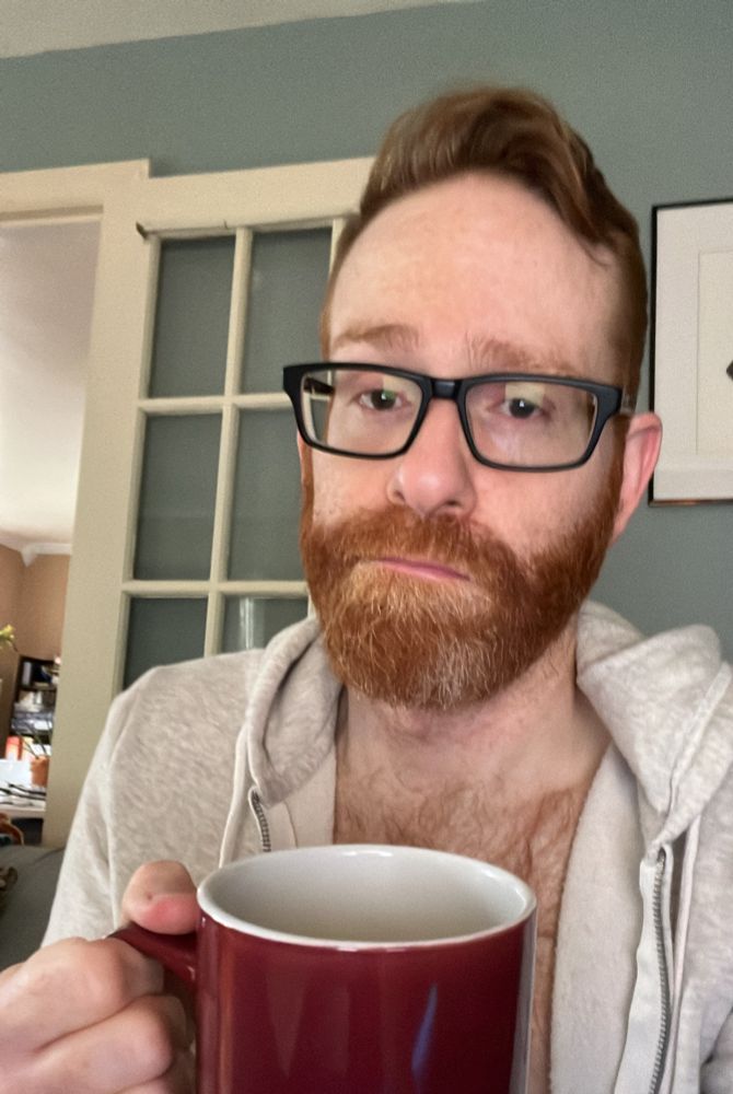A selfie with a cup of coffee where I look tired af
