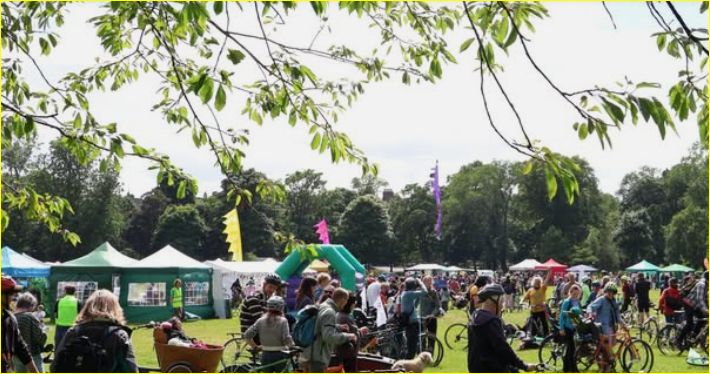Photo of lots of people, bikes and tents at a previous Edinburgh Climate Festival. 