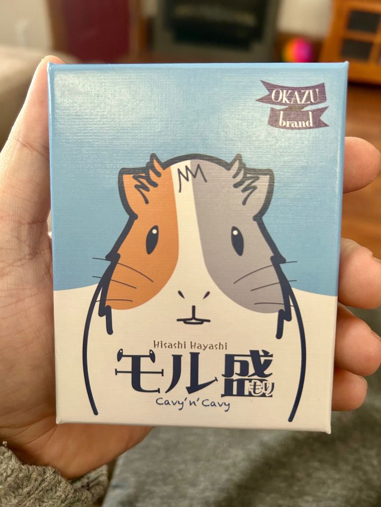 A hand holding the card game Cavy n Cavy 
