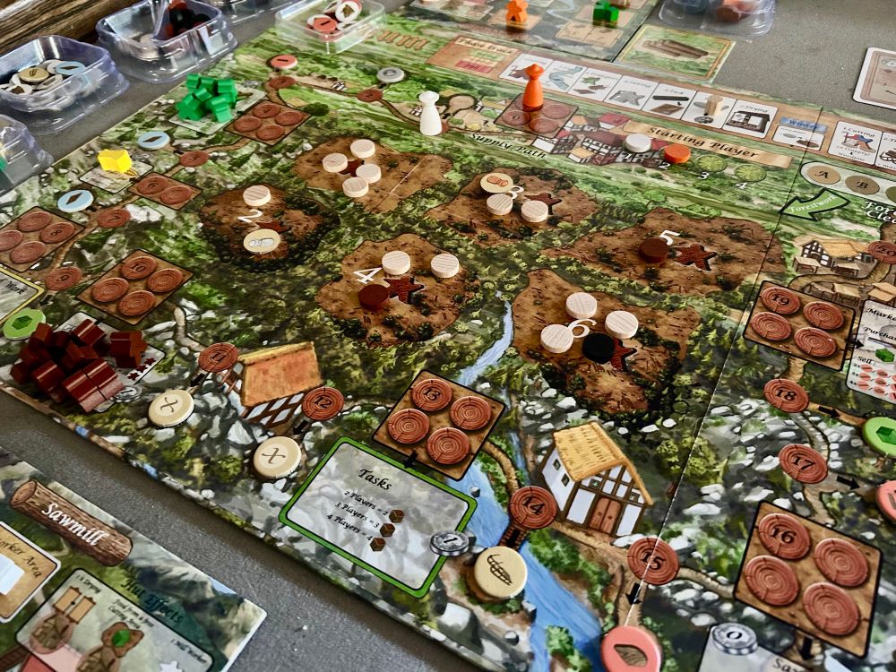 Main game board for Lignum with 6 clearings in the center and a rondel of action spaces around the edge of the board.