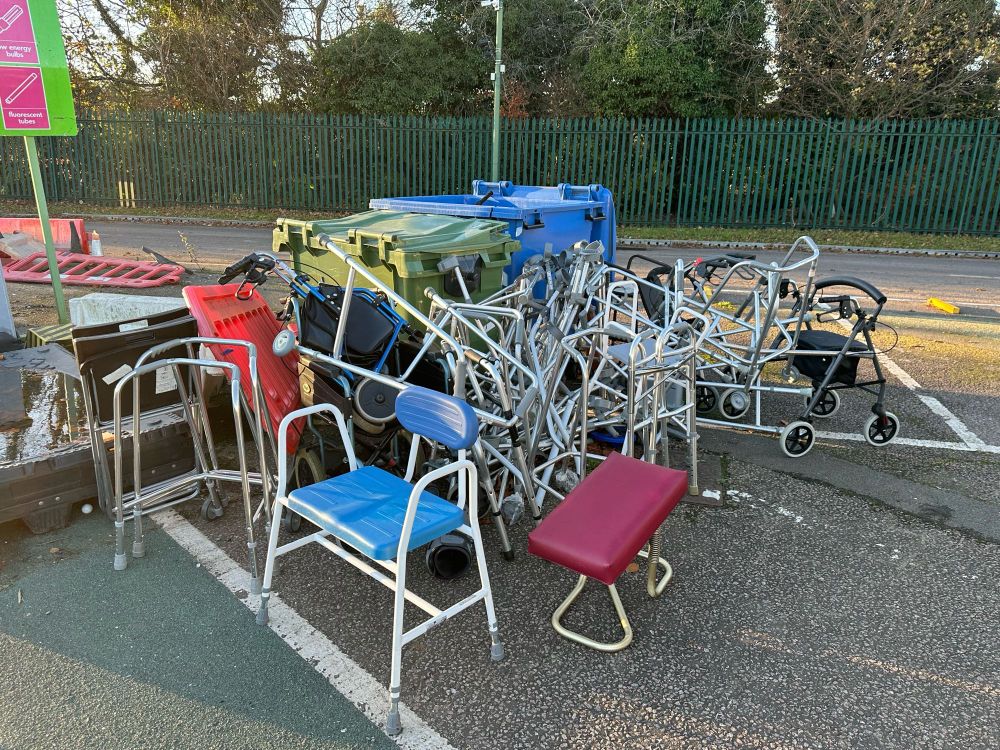 A huge pile of walking frames and other mobility aids.
