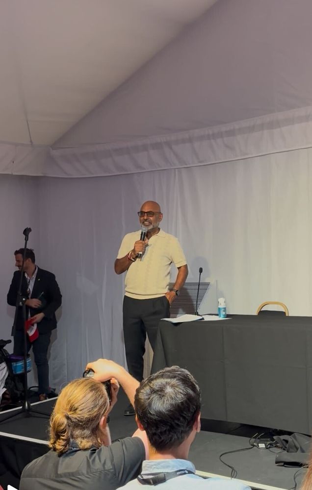 Photo of Asad speaking with a microphone inside the Labour party conference