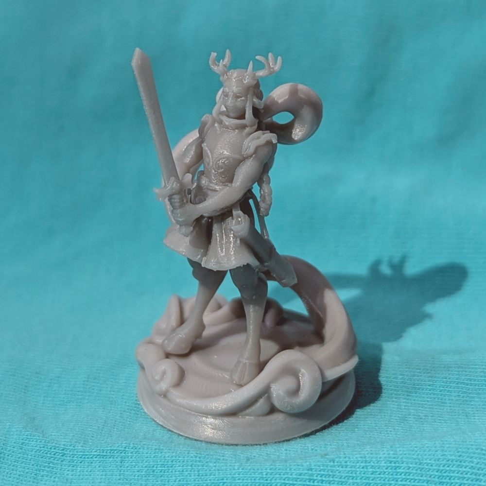 On a teal background, a gray print of a ttrpg miniature on a base: a deer satyr with long braided hair in a skirt, wielding a sword.