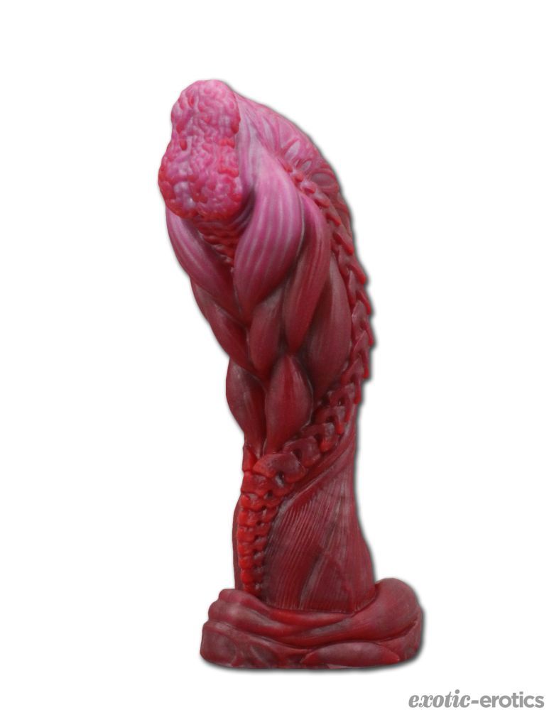 A silicone dildo standing upright, Furantur, a large bulbous head with brain like details at the tip, with rippling musculature and bony spurs down the shaft. A small muscular base at the bottom supports the shaft.