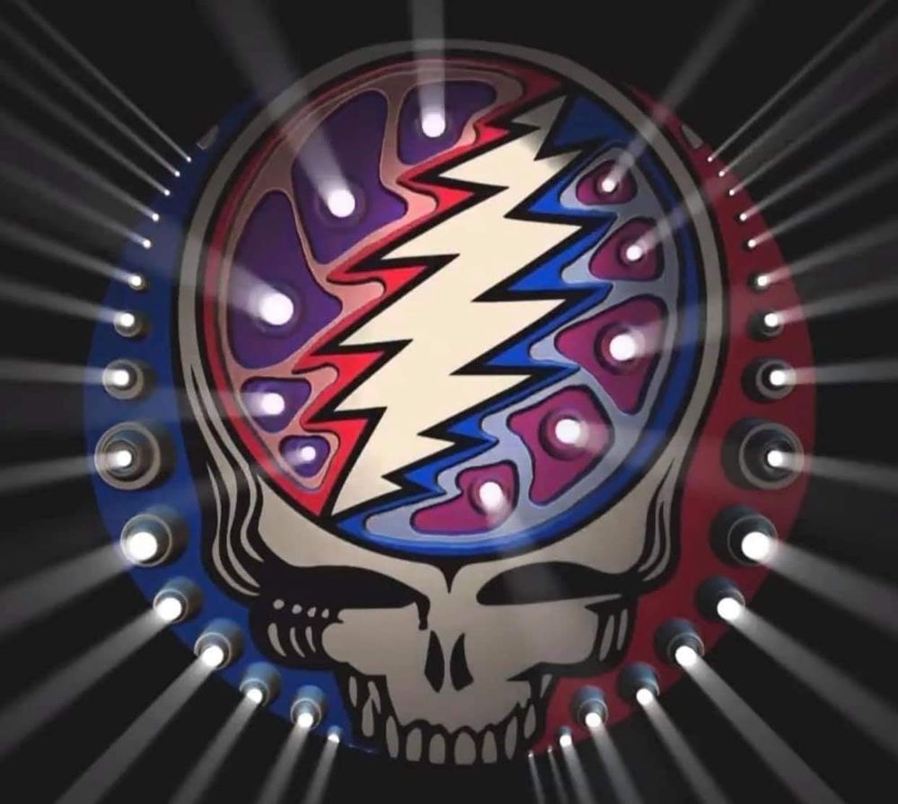 Red white and blue Grateful Dead stealie with holes around  the outside and bolt that have white light pouring through.