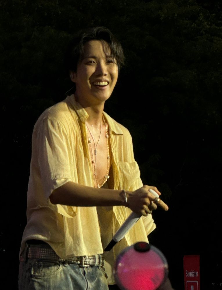hobi with a HUGE WIDE SMILE looking at the fan project at lollapalooza Berlin, now realising what had happened and what it says on the hearts