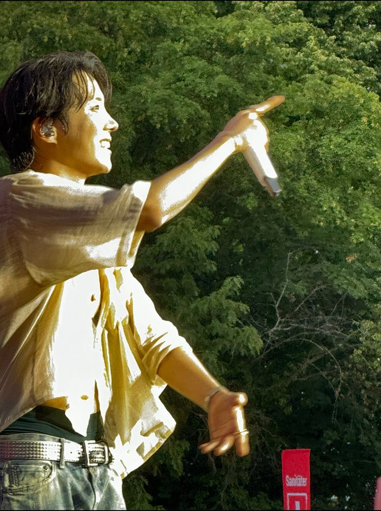 hobi, surprised but starting to smile, pointing at at the crowd at lollapalooza Berlin
