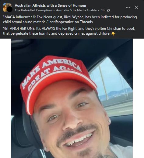 Man wearing a red cap with white text smiling at the camera.
