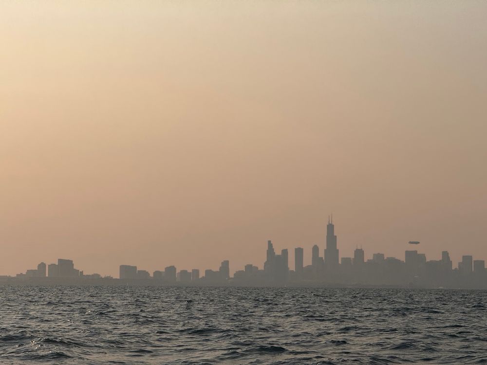 A hazy view of the Chicago skyline taken during sunset from a boat on Lake Michigan. 
