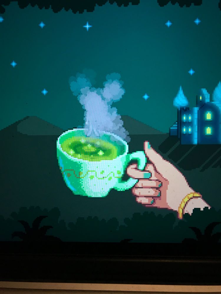 Photo from videogame stardew valley of green tea in a cup help by hand with seafoam green nail polish.