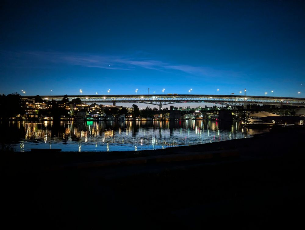 Bridge at night reflecting in water