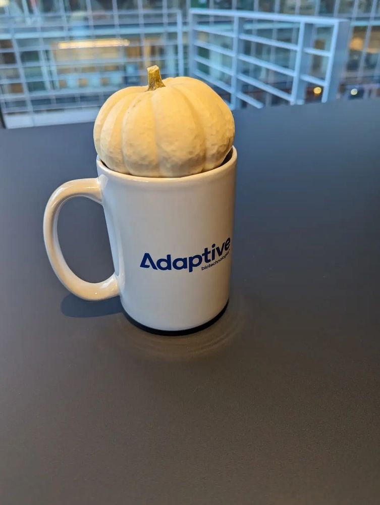 A decorative pumpkin sitting in a coffee mug.