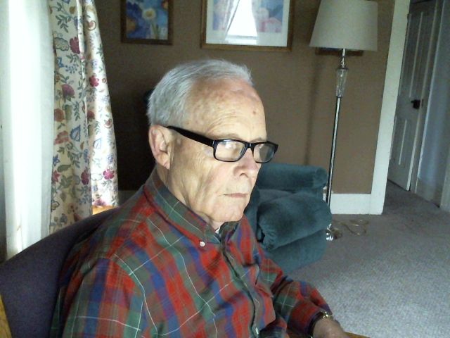 The poster sitting in a chair, looking side eyed towards the window where kids may, in fact, be on the l;awn.