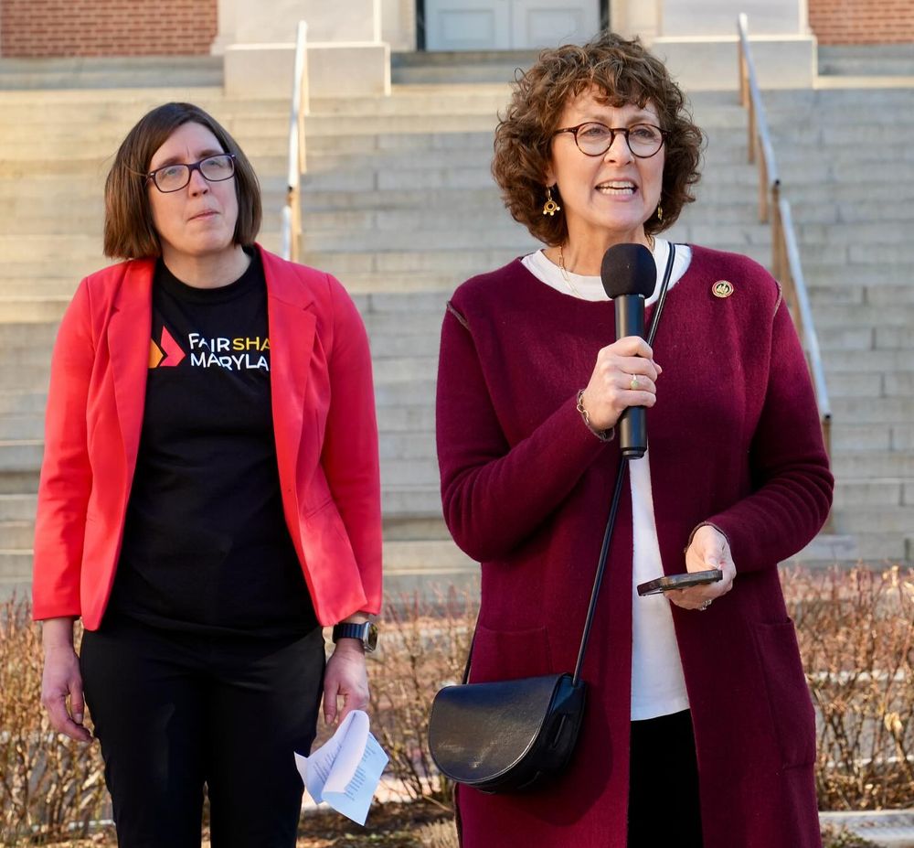 A photo of Kali Schumitz of the Maryland Center on Economic Policy and State Senator Shelly Hettleman both standing outside the Maryland State House on February 4th, 2025 talking to Transit Rider Rally participants about the Fair Share Plan (fairsharemaryland.org).