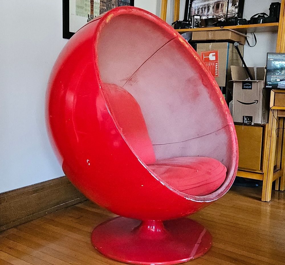 Big bright red Eero Aarnio ball chair sitting in my office nook, and honestly the chair has seen better days.