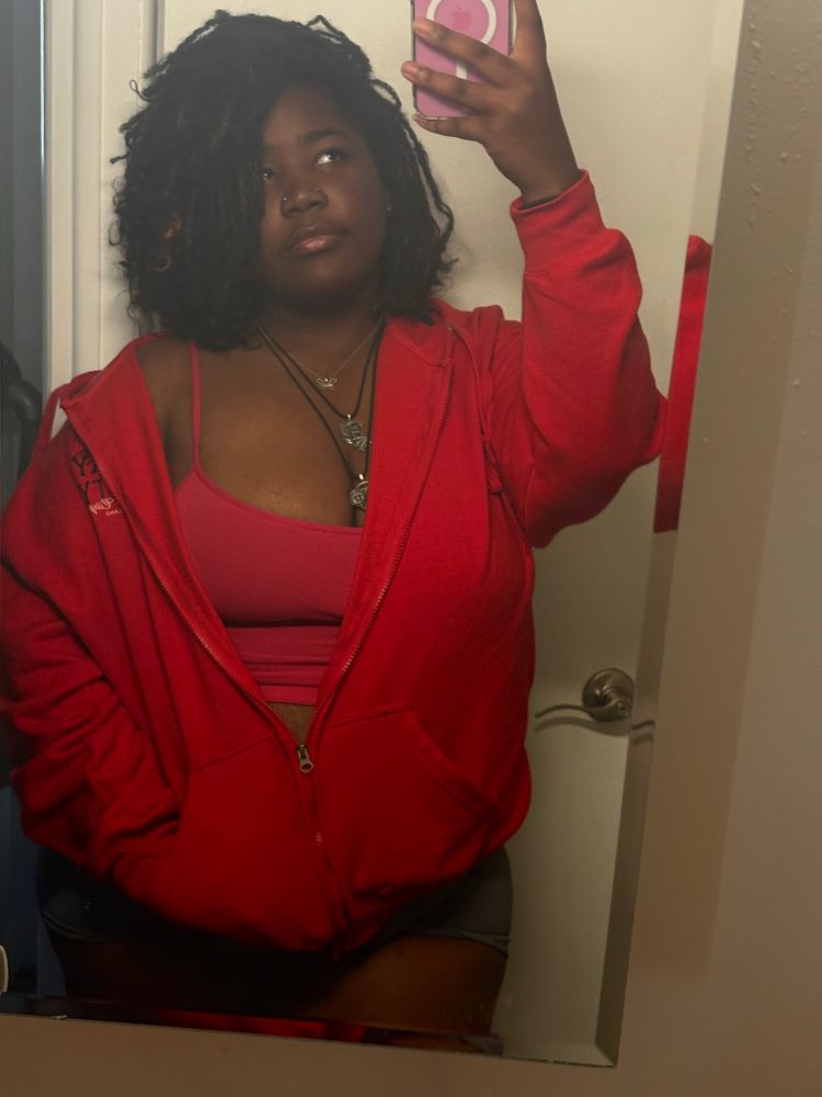 Moon looking super cute in a red zip up hoodie, pink tank top and gray shorts 