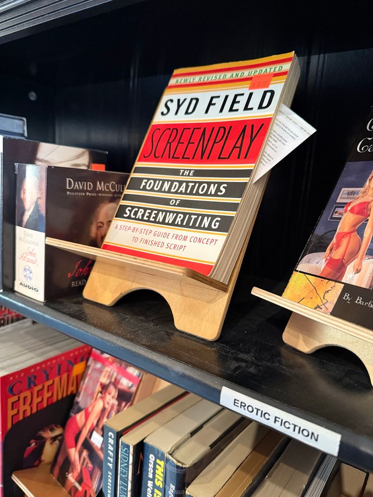 A photo of Syd Field’s Screenplay on a bookshelf titled “Erotic Fiction”