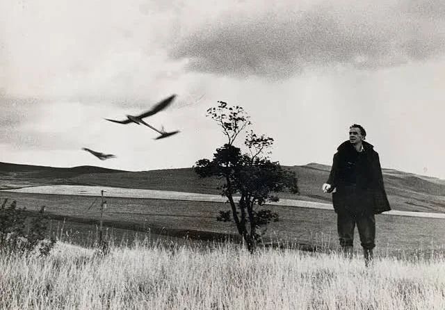 A picture of Ian Hamilton Finlay flying paper planes at his home, Stonypath.