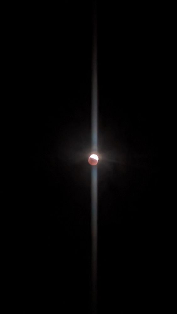 Picture of the moon during an eclipse. It is half red and half white.