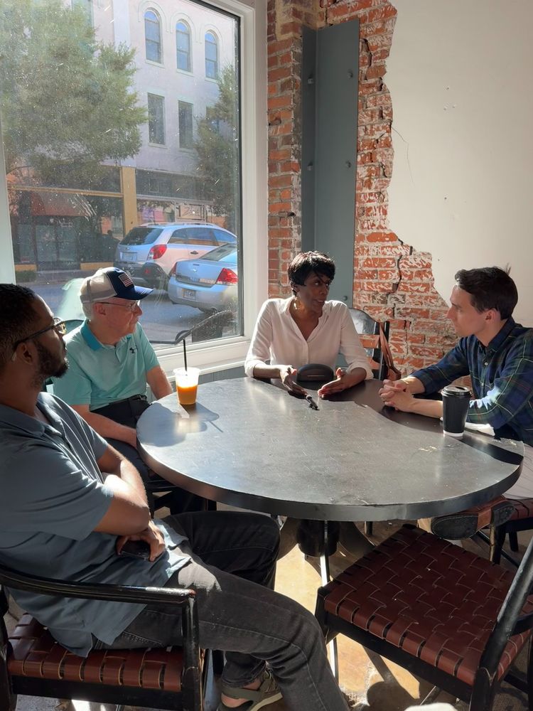 Mike, Dr. Gary Miller, a young man, and middle aged woman having discussion at coffee table. 