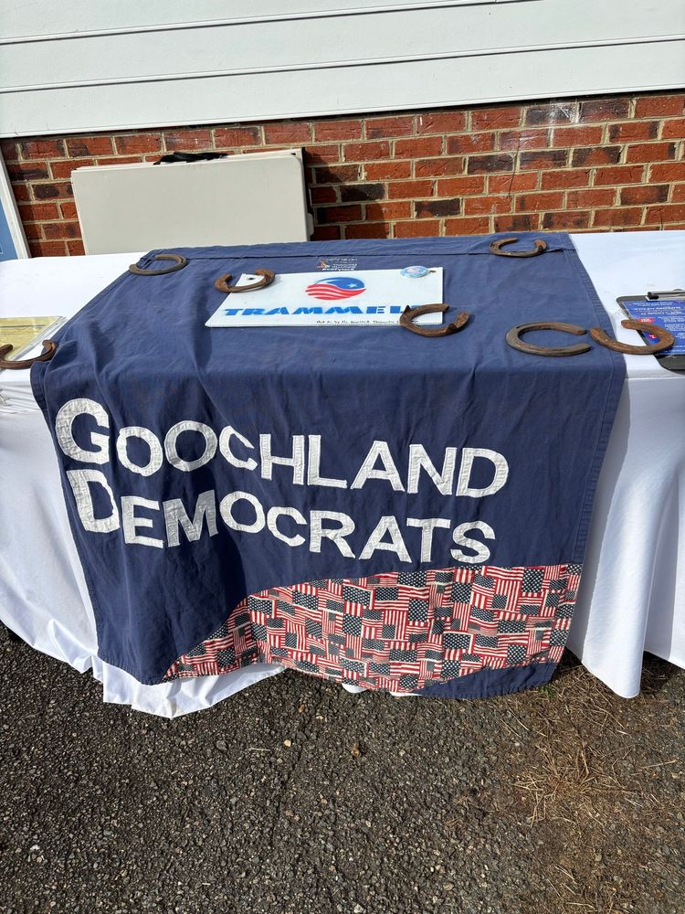 The hand quilted banner for the Goochland Democrats hangs on a table, weighed down by horse shoes.