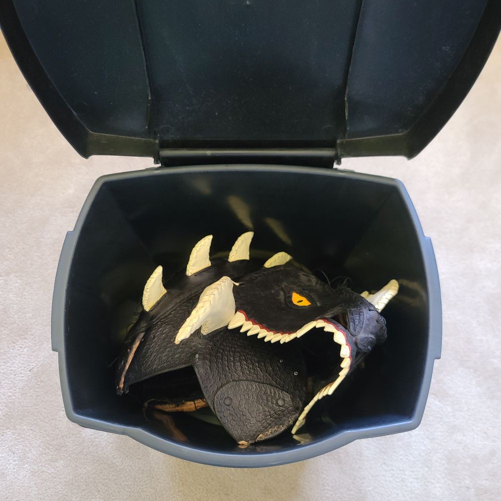 The dragon helmet destroyed in a garbage can.