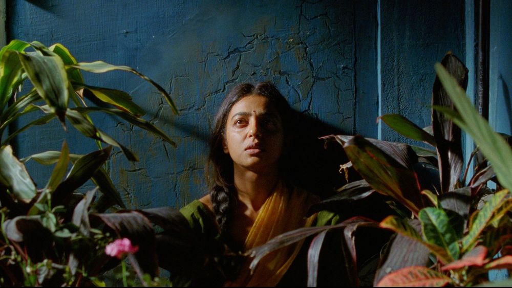 Photo from The Upbringing, Radhika Apte pretty brown skinned India young woman surrounded by plants, looking forlorn