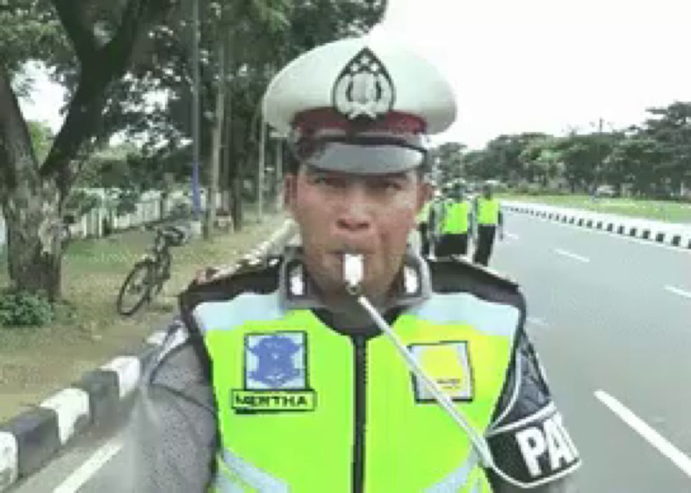 a police officer is smoking a cigarette while wearing a yellow vest that says pa on it .