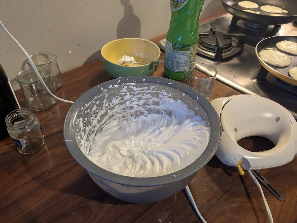 Dans un saladier plastique gris, à côté d'un fouet électrique, les blancs montés en neige avec du sucre, pour faire la meringue sur la tarte au citron