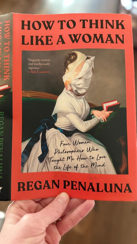 Book cover “How to Think Like a Woman” by Regan Penaluna of a woman in a white dress holding a book with her head wrapped in white fabric. 