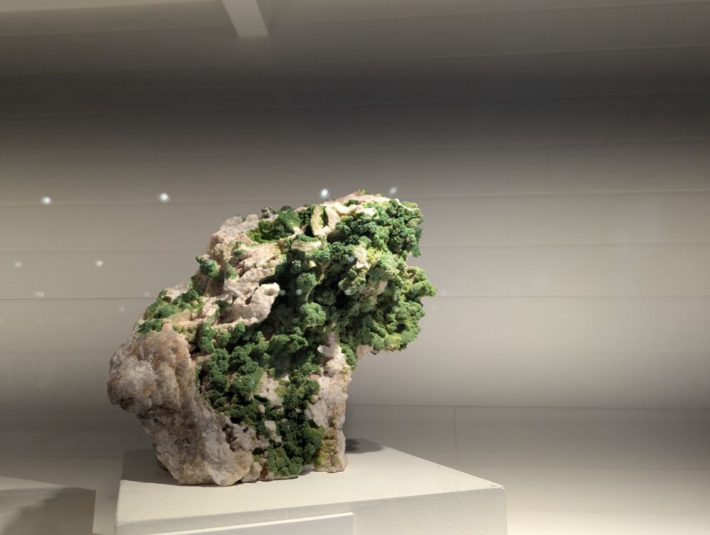 A grey/white rock that has green outcroppings that look a little fuzzy