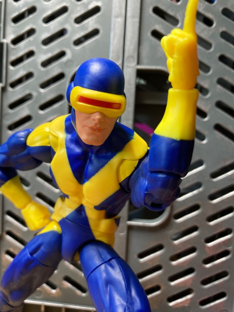 Cyclops of the X-Men points to the sky while bending forward