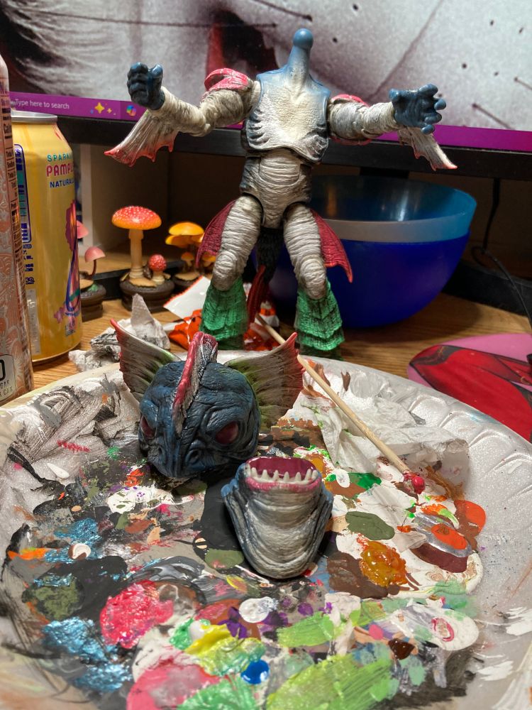 photo of the Lightning Collection Pirantishead monster from MMPR. He is a fish guy and has had his head and lower jaw removed from his body for painting. In fact the head bits are sitting on a foam plate smeared with paint from at least last year. Maybe more.