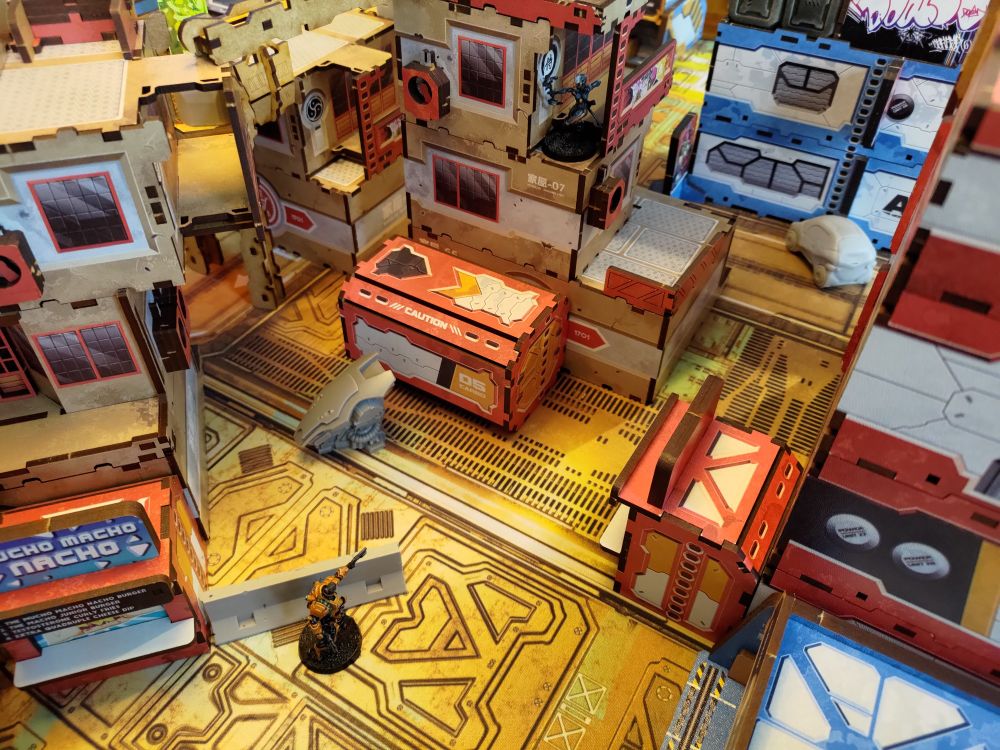 A ninja and an engineer in heavy armor from Corvus Belli Infinity fighting it out in a warmly colored cyberpunk alley.