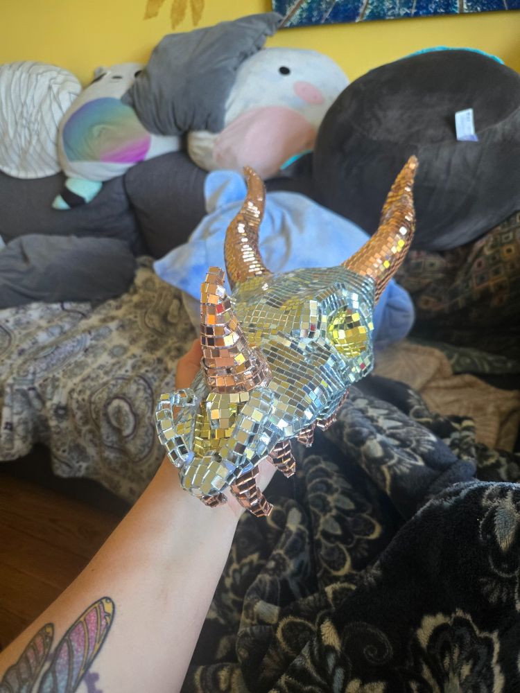 A dragon skull the exterior of which is covered with silver, copper, and gold mirrors