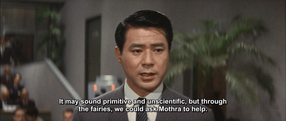 A screenshot from a kaiju movie with a Japanese man in a suit saying, "It may sound primitive and unscientiific, but through the fairies, we could ask Mothra for help."
