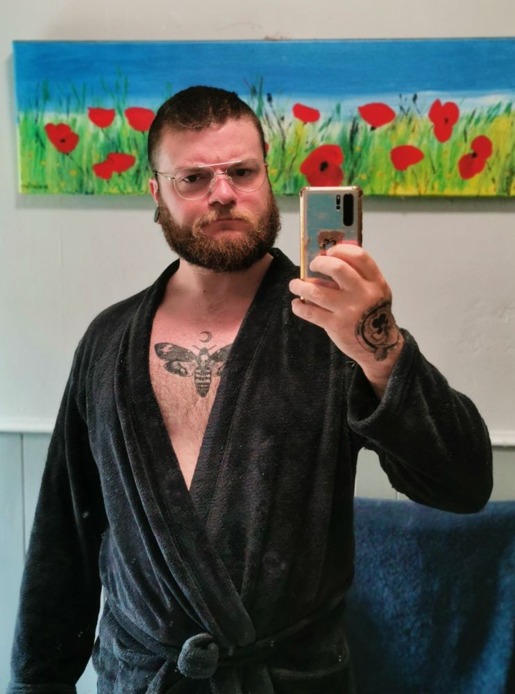 Mirror selfie of me in a dark blue bathrobe and a pair of aviator dad style glasses