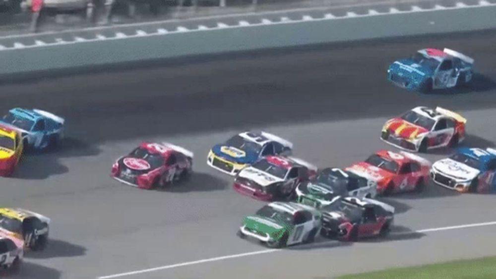 a group of race cars are racing on a track and one of them has a coca cola logo on the front