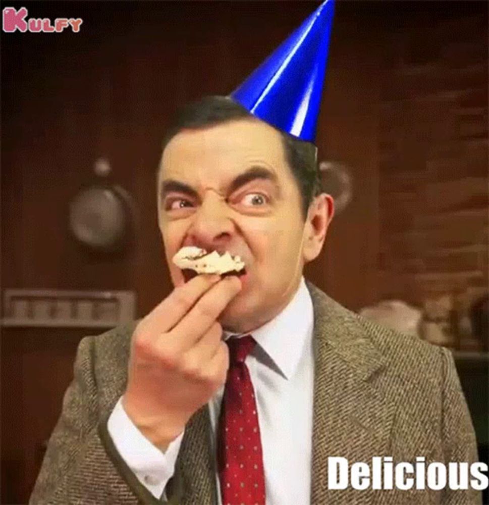 mr bean is wearing a party hat and eating a piece of food .