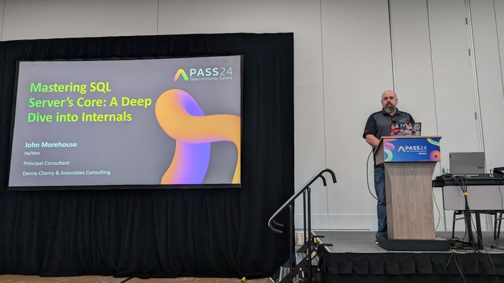 John on stage with his title slide up